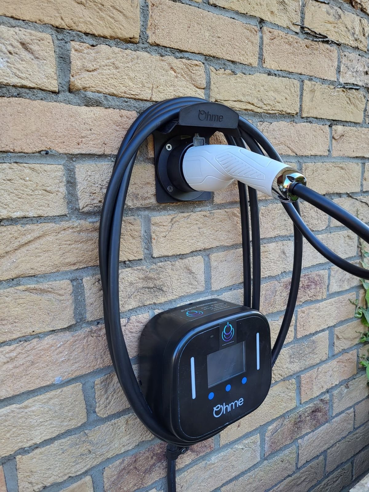 Ohme Home Pro EV charger mounted on a brick wall