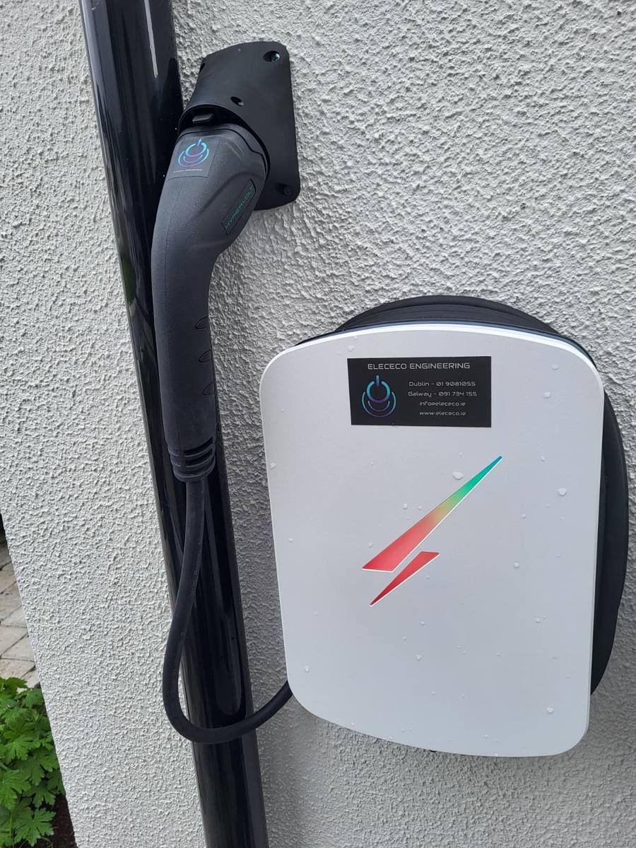 White smart EV charger mounted on a house wall by Elececo Engineering