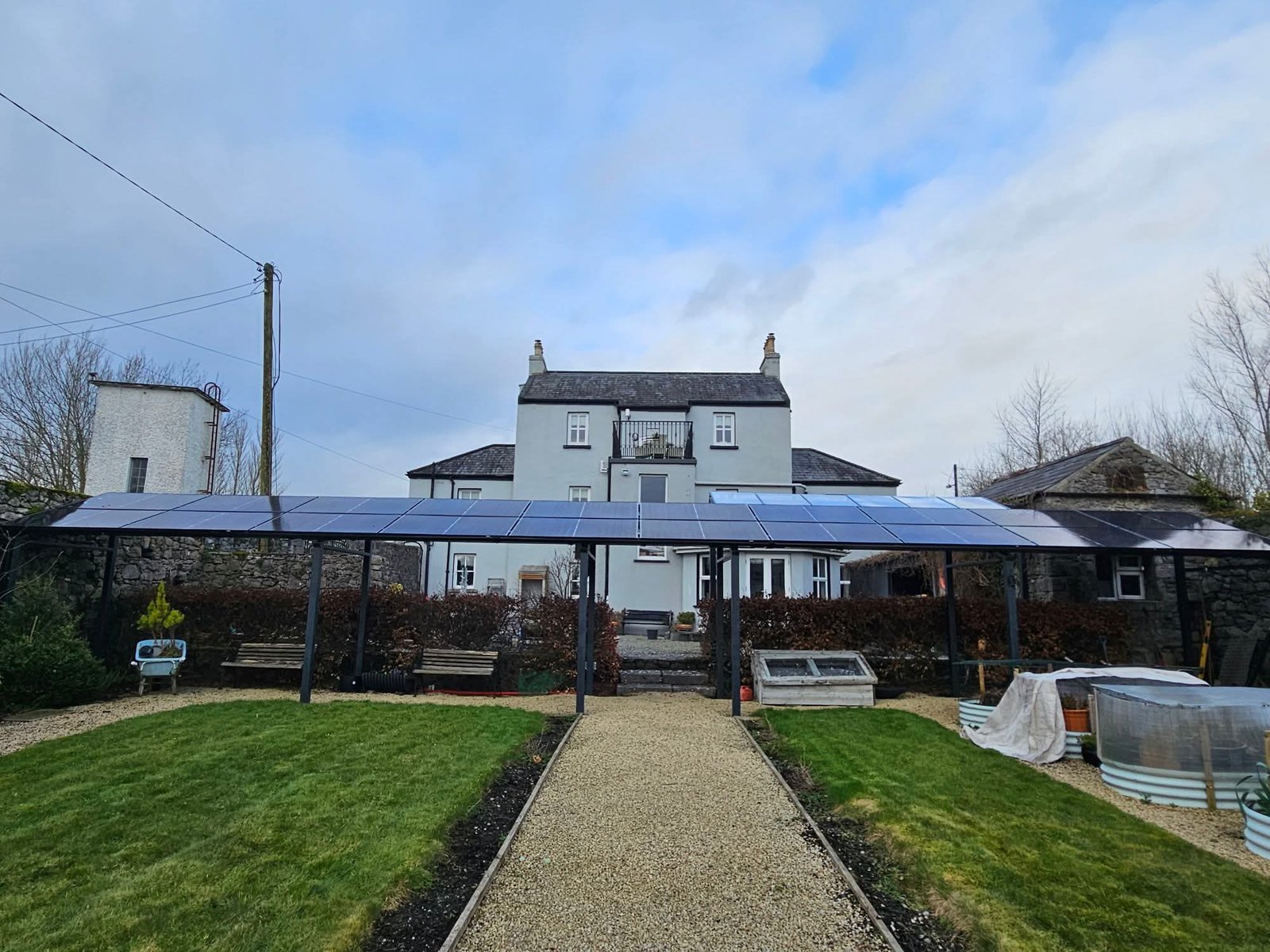 Ground-mounted Solar PV array in front of a period farmhouse