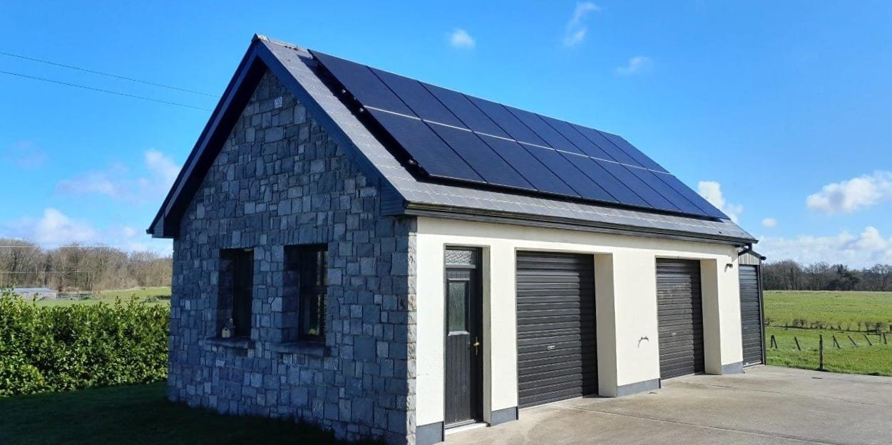 Solar PV panels on the roof of a detached stone-clad garage, by Elececo Engineering